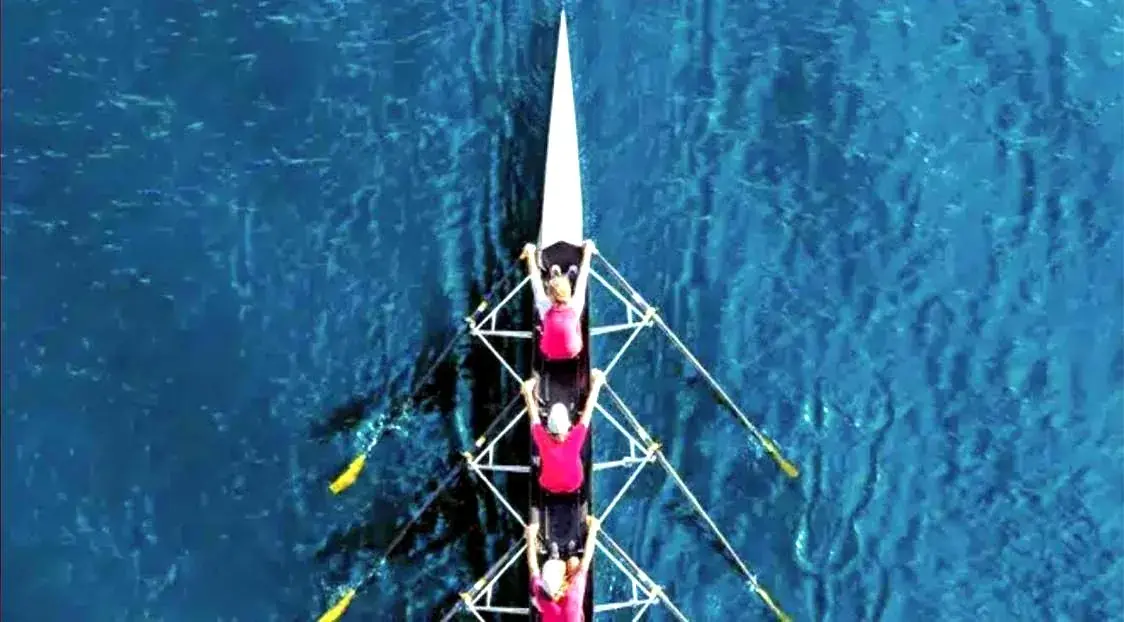 Athletes rowing in a crew boat, demonstrating active recovery