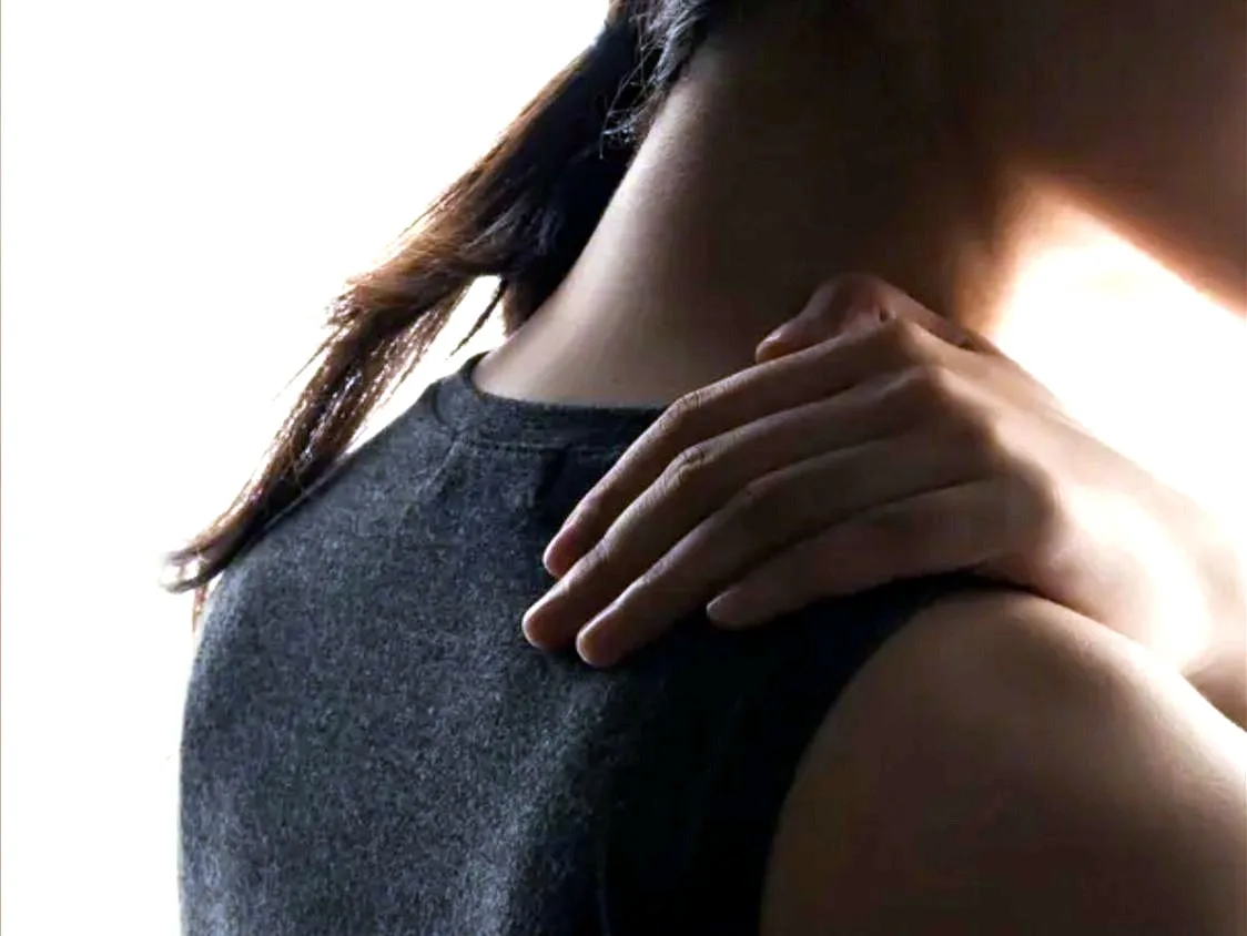 Person holding shoulder in pain, seeking Orthopedic care